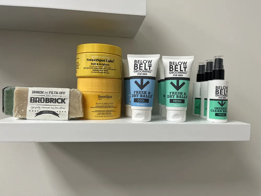 Body-care products displayed on a shelf at Sacred Beauty, including Bushbalm and Below the Belt